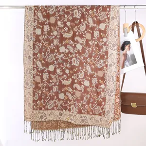 Dettaglio ravvicinato della sciarpa jacquard paisley marrone con frange sottili e trama tessuta