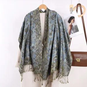 Dettaglio ravvicinato del motivo paisley retrò e frange di una sciarpa etnica blu