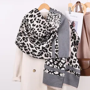 Detail of leopard print scarf with tassels styled on a beige coat for autumn fashion