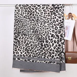 Macro view of leopard print scarf with fringe hem and contrasting grey striped details