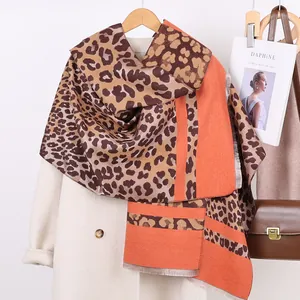 Detail of leopard print and orange cashmere-feel scarf with soft fringe trim details