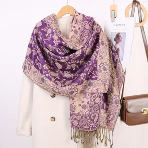 Dettaglio della sciarpa jacquard Paisley viola con frange su un cappotto beige