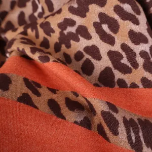 Leopard print cashmere-like scarf with vibrant orange stripes for stylish winter warmth