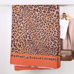 Detail of leopard print scarf with orange color block stitching and soft tassels