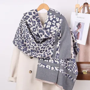 Detail of cashmere-like scarf featuring leopard print with fringe and stylish daphine mag