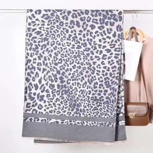 Detailed close-up of leopard print cashmere feel scarf with soft texture and tassels