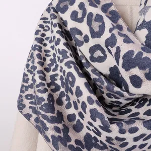 Detail of leopard print faux cashmere scarf with blue-grey patterns on a cream base