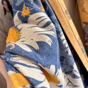 Detail shot of the jacquard daisy pattern on a premium blue and yellow cashmere scarf