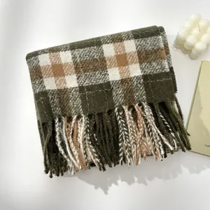 Close-up of olive green checkered wool scarf with long tassel details and thick texture
