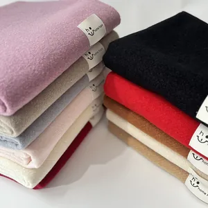 Vista dettagliata della consistenza morbida e delle etichette delle sciarpe di cashmere