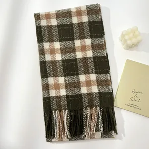 Close-up of thick plaid wool scarf texture with fringe tassels in green and brown