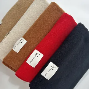Primo piano di sciarpe in finto cashmere piegate in cinque colori con dettaglio logo