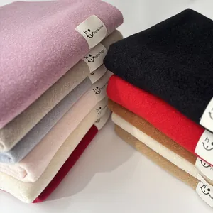 Dettaglio di sciarpe morbide effetto cashmere in vari colori con etichette tessute