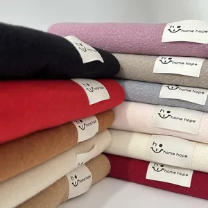 Primo piano di sciarpe colorate stile cashmere impilate con toppe con logo del marchio