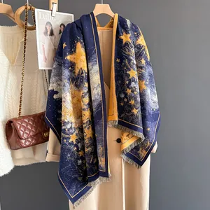 Navy blue cashmere feel shawl with yellow stars and fringe, paired with beige coat