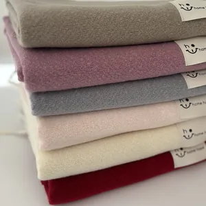 Primo piano di sciarpe in cashmere colorate piegate con trama morbida ed etichette