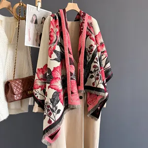 Detailed view of floral print shawl with red flowers and delicate fringed edges