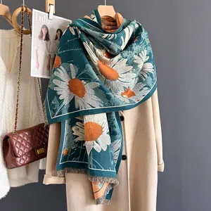 Close-up of daisy jacquard pattern and tassel fringe on dark green cashmere scarf