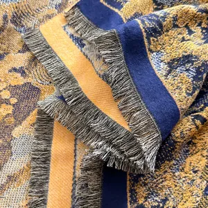 Detail of navy and gold jacquard scarf showing thick texture and fringed edges