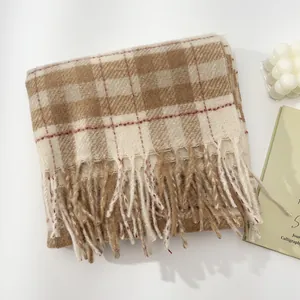 Detailed close-up of brown plaid wool scarf with long tassels and soft warm texture