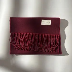 Detail view of burgundy wool scarf showing soft texture and long fringe tassels
