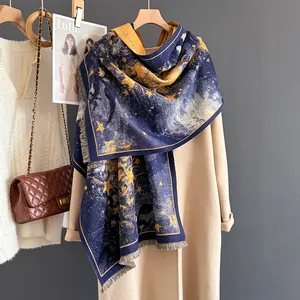 Detail of starry night art scarf with fringe edges paired with a beige winter coat