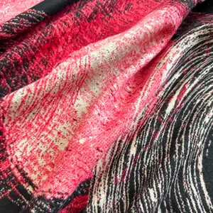 Close-up of thick winter shawl fabric with red, black, and white cashmere-like texture