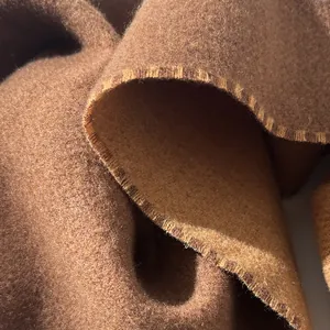 Detailed close-up of dark brown wool scarf with premium overlock edge and soft texture