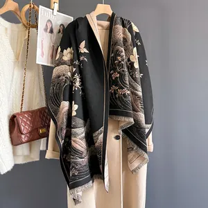 Dettaglio di elegante scialle in cashmere nero e oro con frange su un cappotto di lana