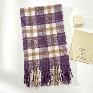 Detail of wool-like plaid scarf featuring purple and brown checks with fringe tassels