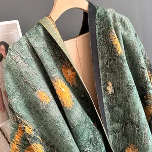 Dettaglio ravvicinato dello scialle jacquard verde muschio con fiori gialli e cerniera
