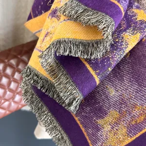 Close-up of jacquard weave fabric and fringe tassels on a purple winter shawl
