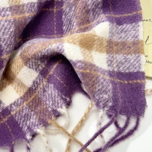 Close-up of thick plaid wool scarf with purple and beige fringe detail and soft texture