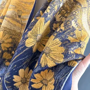 Detailed close-up showing the thick texture and golden daisy pattern on the warm scarf