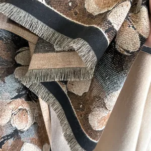 Close-up of winter scarf showing floral jacquard pattern and premium fringe tassels