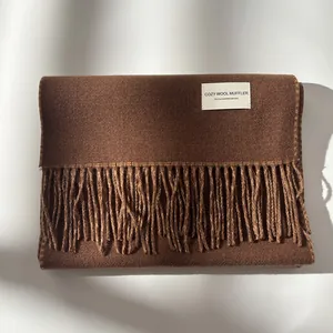 Close-up of premium dark brown wool scarf with dense texture and soft fringe details