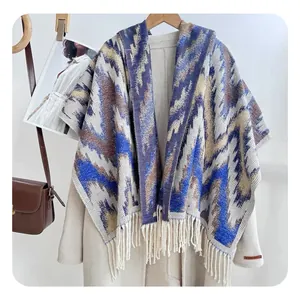 Detail showing geometric zigzag pattern and cream tassels on soft knit shawl scarf