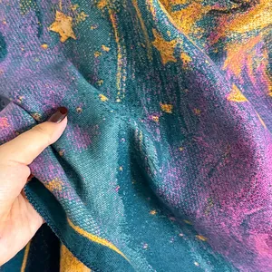 Close-up showing the thick woven texture and starry galaxy pattern of this winter shawl