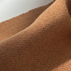 Macro shot of soft camel wool fabric texture and fine stitching on the winter scarf