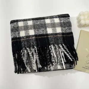 Macro detail of thick plaid wool scarf with long tassels and classic checkered pattern