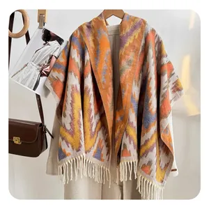 Close-up of geometric wave pattern and fringe detail on ethnic knit shawl cape