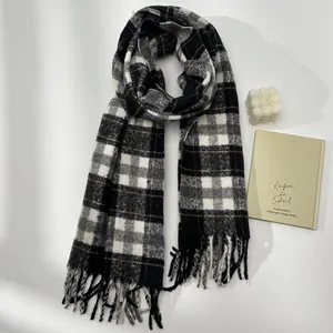 Close-up of thick wool plaid scarf with grey check pattern and soft fringe tassels