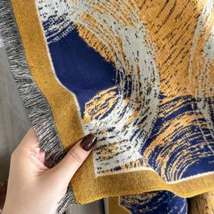 Close-up of thick navy and yellow jacquard cashmere-feel scarf with elegant fringes