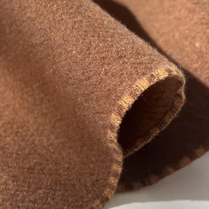 Macro detail of thick brown wool scarf fabric with refined stitching and soft texture