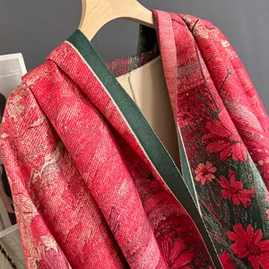 Detail of heavy jacquard knit shawl featuring dark red and green floral patterns