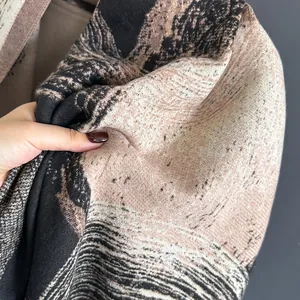 Detail view showing the soft cashmere-like texture and artistic landscape print of the scarf