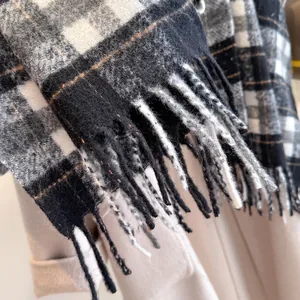 Close-up of classic grey plaid wool scarf showing thick knit texture and tassel details