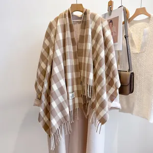 Detailed macro view of beige plaid scarf texture with elegant soft fringe edges