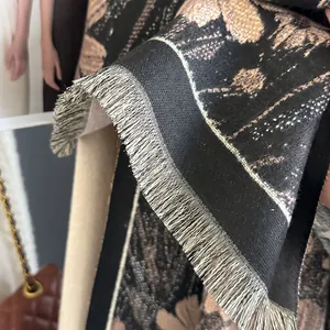Detailed close-up of premium black and gold floral jacquard scarf with fine fringe edges