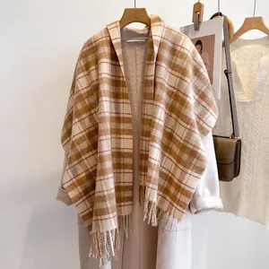 Classic checkered wool scarf for women with tassels hanging on a wooden hanger with coat